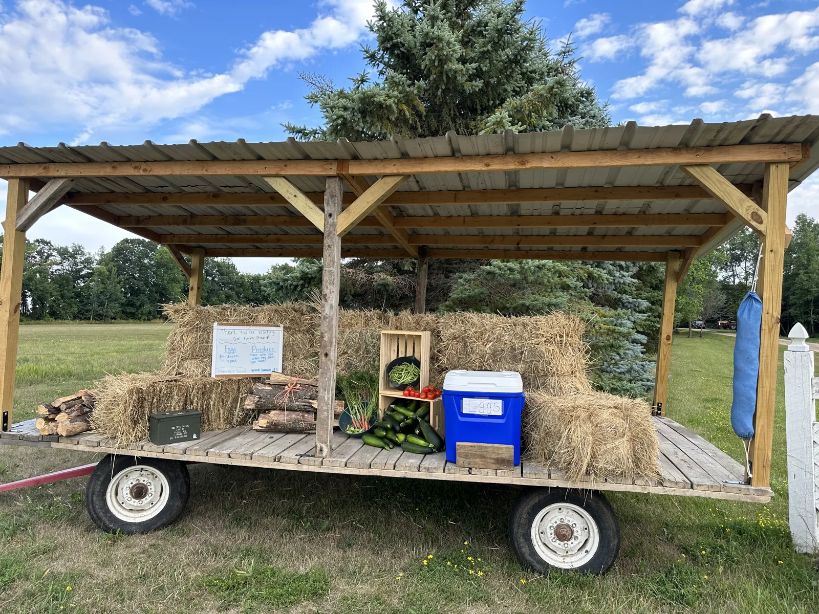 The Picray farm stand wagon stocked under its wooden roof